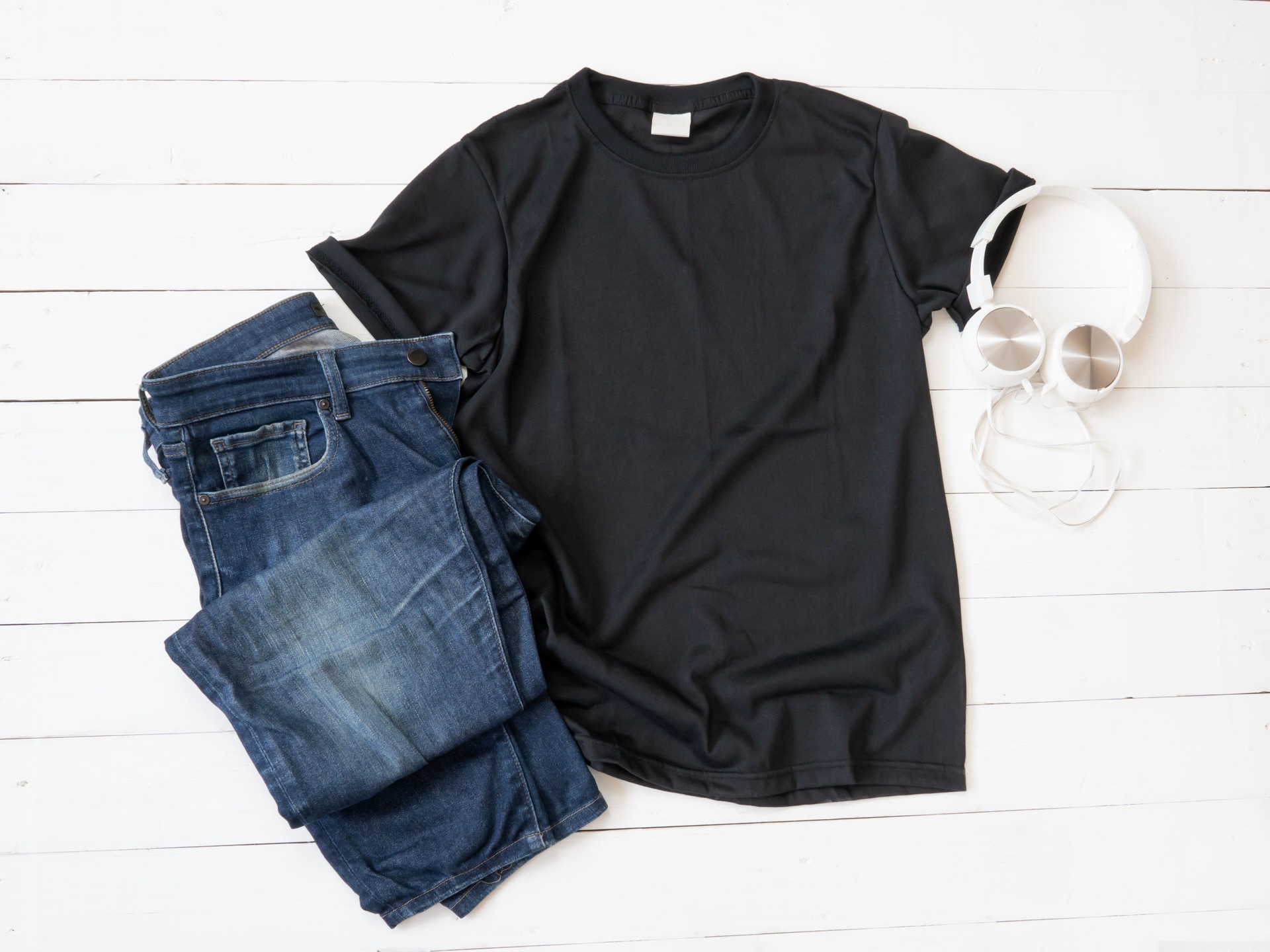 Black T Shirt mockup, earphones and Jeans on white wood background